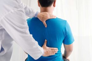 Person taking a walking break beside a desk while gently stretching their shoulders